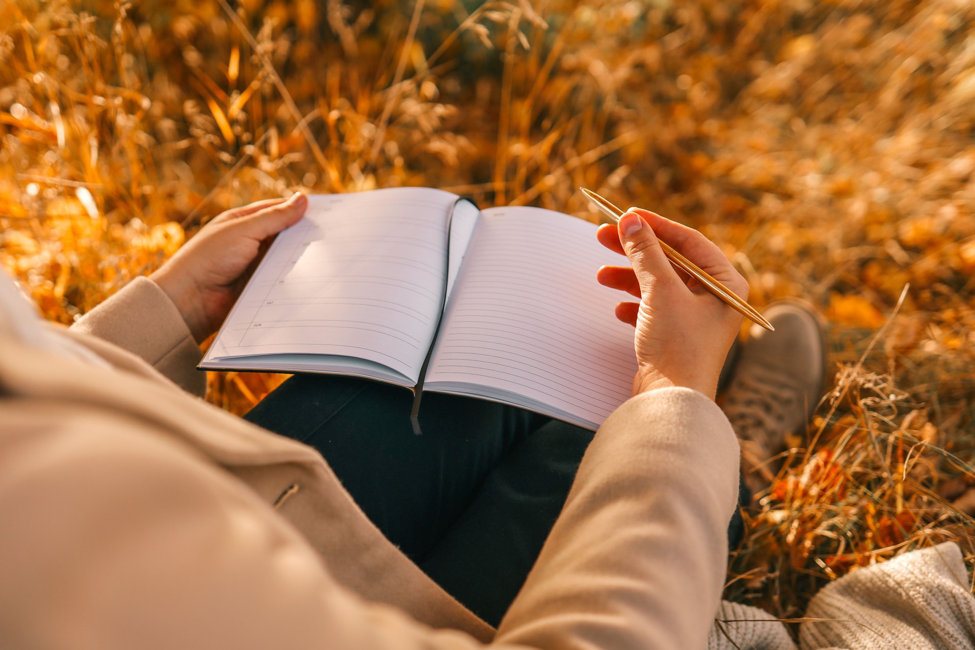 Reflecterend moment met pen en notitieboek in de natuur – coaching, rust en zelfinzicht.